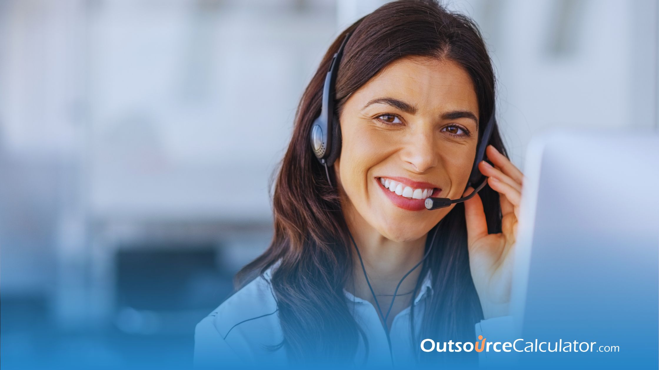 a call center agent smiling while talking to a customer using headphones