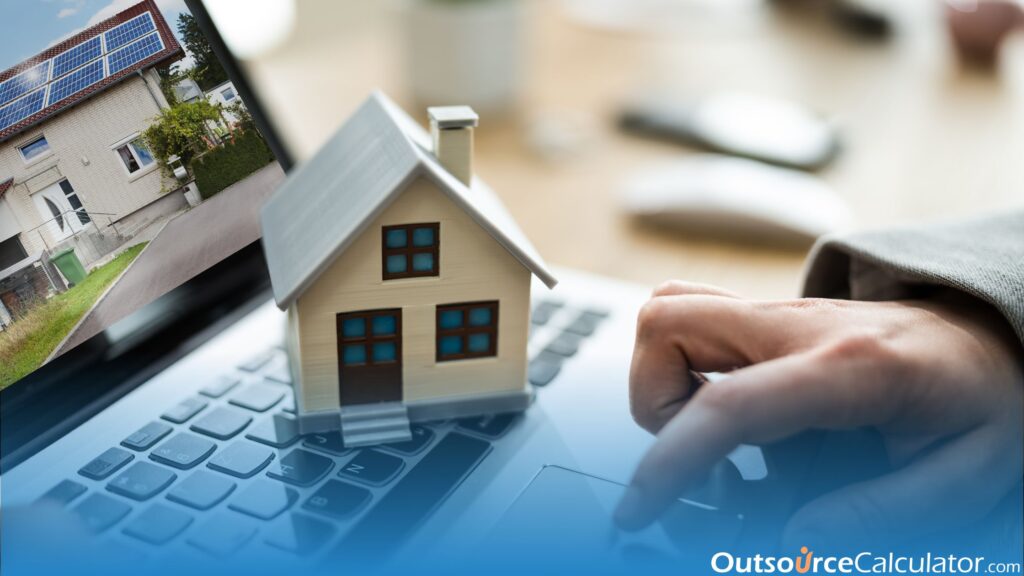 a person typing on a laptop and a miniature of a house